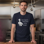 Man wearing a navy blue t-shirt  t-shirt with a male chef graphic and text "Your Opinion Wasn't Part of the Recipe" in a kitchen setting.