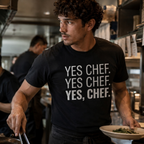 Chef wearing a black t-shirt with 'YES CHEF. YES CHEF. YES, CHEF.' text in a kitchen setting.