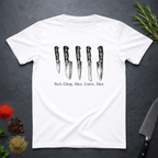 White t-shirt with knife graphic and text 'Peel, Chop, Slice, Carve, Dice' on a dark surface with kitchen items.