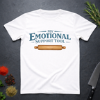 White t-shirt with 'My Emotional Support Tool' text and rolling pin graphic on a dark surface.