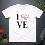 White t-shirt with 'LOVE' design featuring a chef's hat as the letter O on a dark surface.