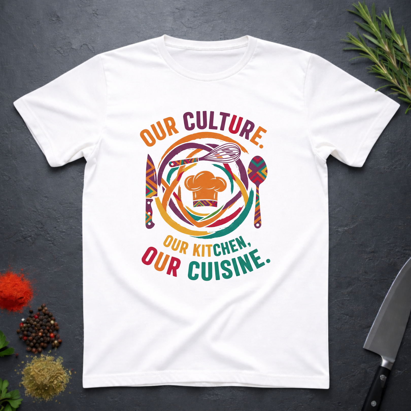 White t-shirt with colorful African graphic and text "Our Culture Our Kitchen, our Cuisine: on a dark surface.