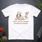 White t-shirt with a graphic of a woman in a chef's outfit and text "That's cute, you thought I wanted your opinion." On a dark surface.