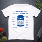 White t-shirt with 'Anatomy of a Perfect Burger' graphic on a dark surface with kitchen items.