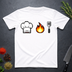 White t-shirt with pixelated chef hat, flame, and spatula design on a dark surface.